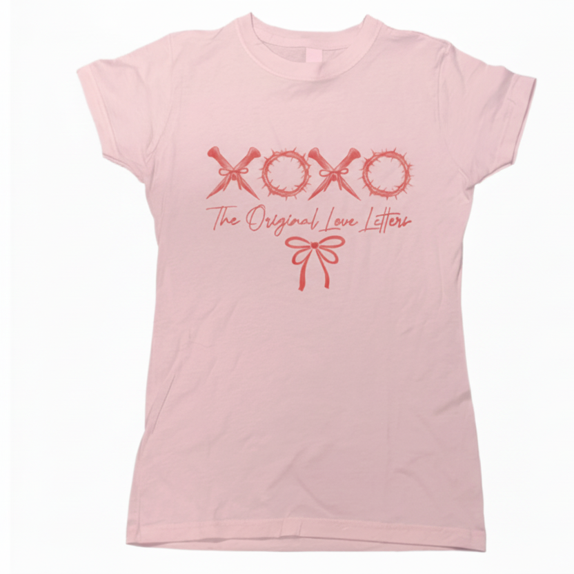 Pink t-shirt with 'XOXO The Original Love Letters' text and bow graphic on a white background, faith-based clothing, God clothing